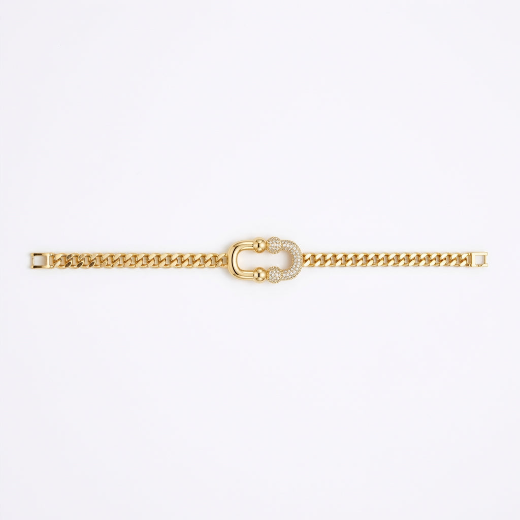 A gold chain bracelet featuring a central horseshoe-shaped charm embellished with small white stones, displayed vertically against a plain white background.
