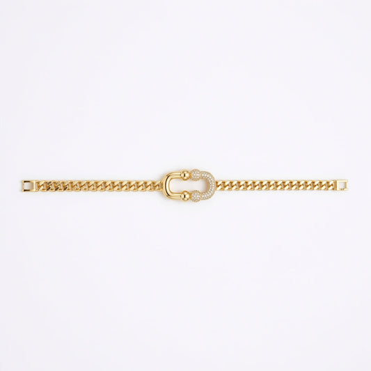 A gold chain bracelet featuring a central horseshoe-shaped charm embellished with small white stones, displayed vertically against a plain white background.